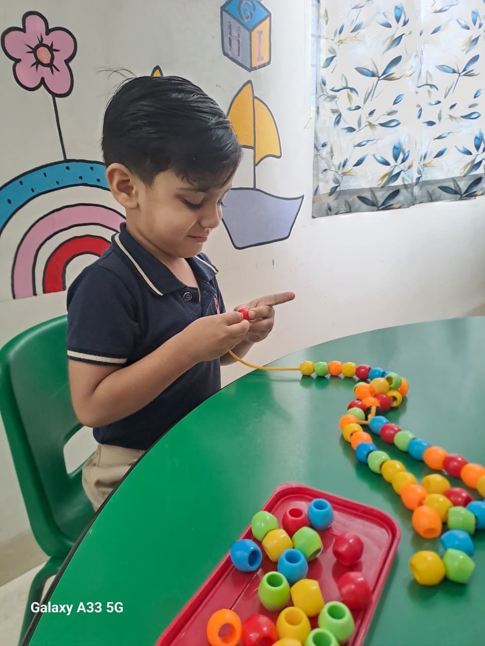 Two children colouring in a book at a painted classroom table