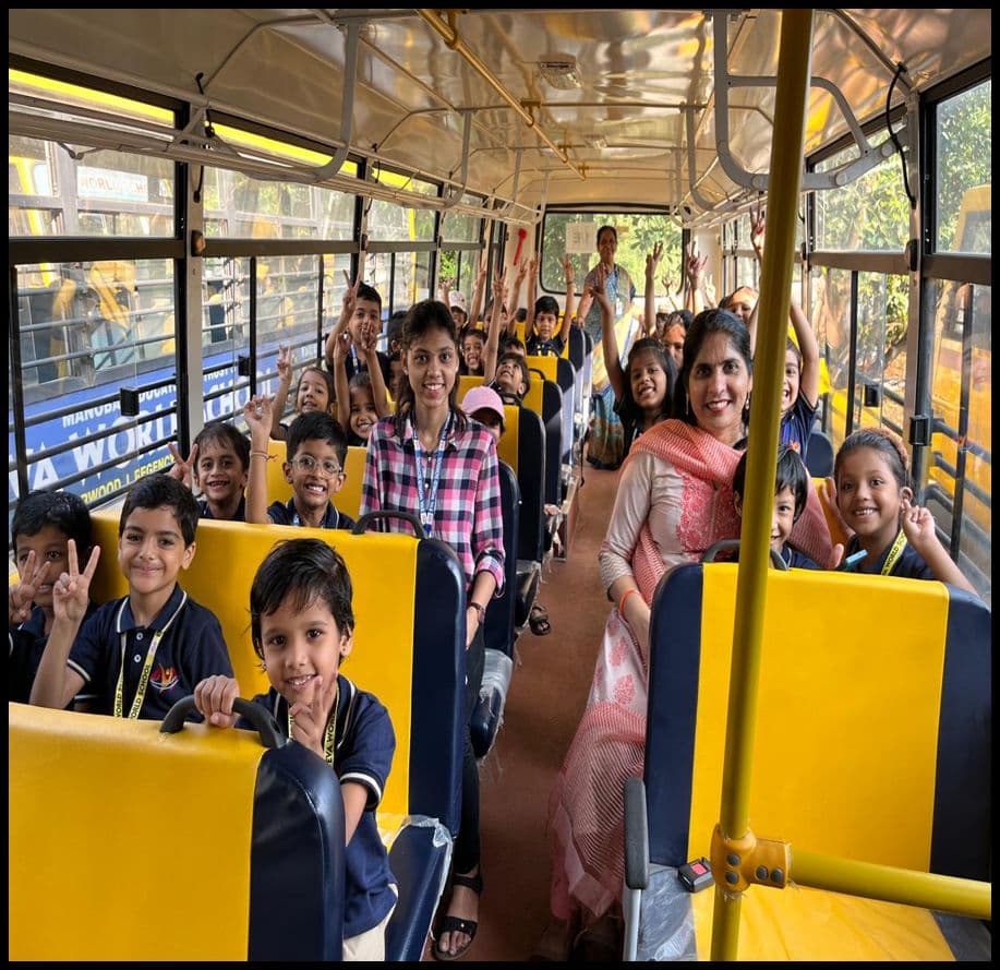 Students and a teacher smiling on a yellow school bus