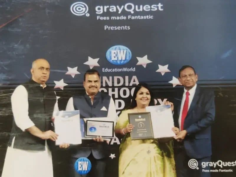 Eva leadership with award plaques at an Education World ceremony